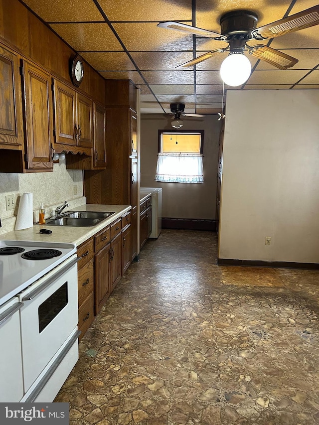 kitchen featuring a drop ceiling, sink, ceiling fan, and range with two ovens