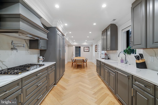 kitchen featuring sink, crown molding, tasteful backsplash, appliances with stainless steel finishes, and light parquet floors