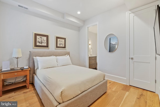 bedroom featuring light hardwood / wood-style floors and ensuite bathroom