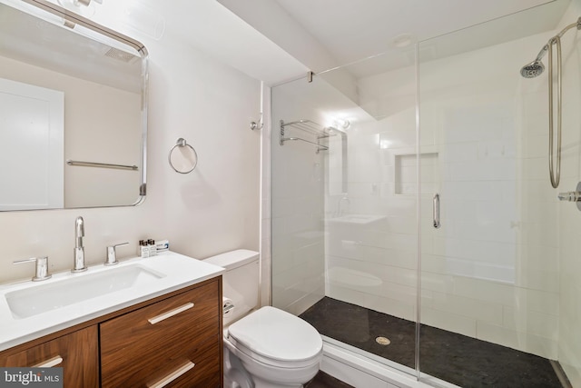 bathroom featuring vanity, toilet, and a shower with door