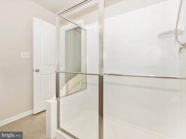 bathroom with an enclosed shower and tile patterned floors