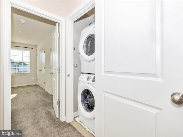 laundry room featuring stacked washing maching and dryer and light colored carpet