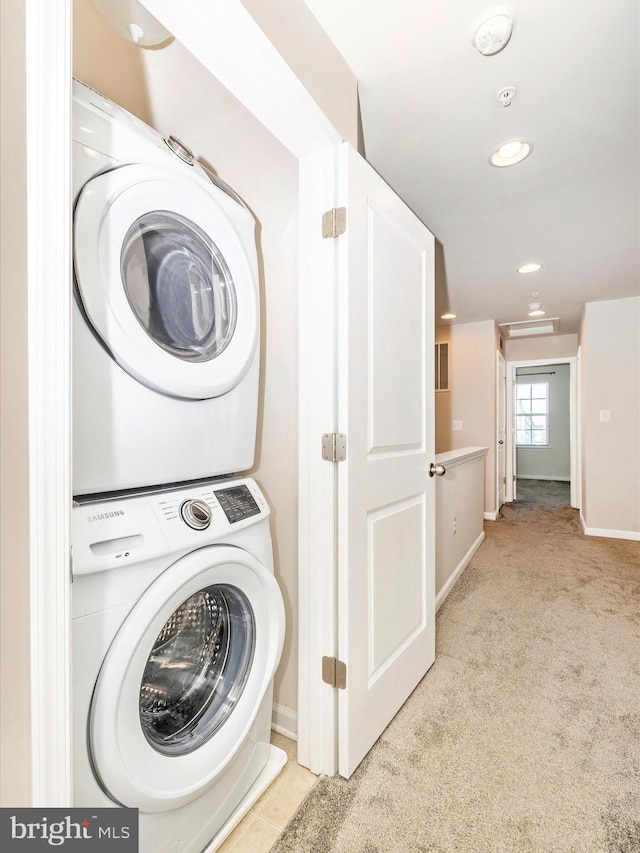 washroom with light colored carpet and stacked washer and clothes dryer