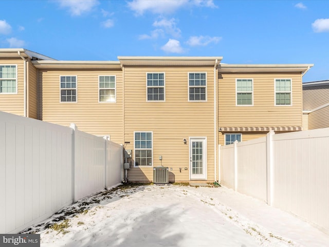 snow covered house featuring central AC unit