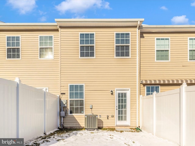 snow covered house featuring central air condition unit