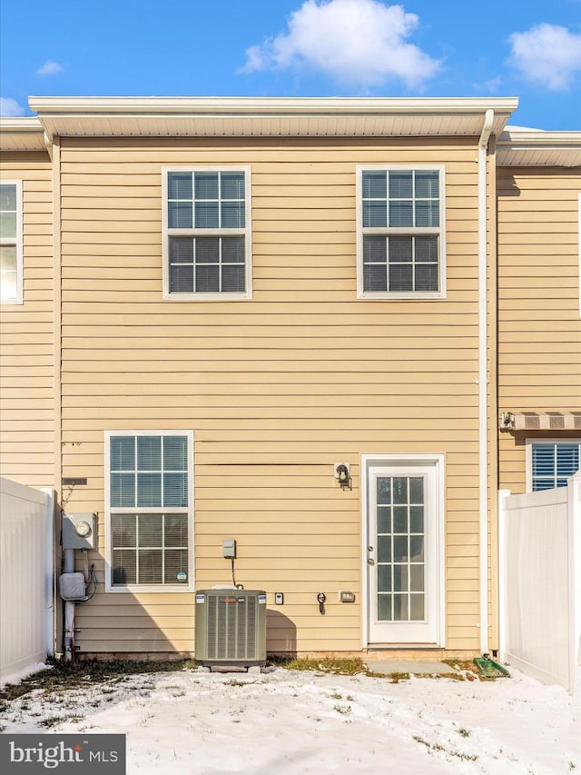 snow covered rear of property with central AC