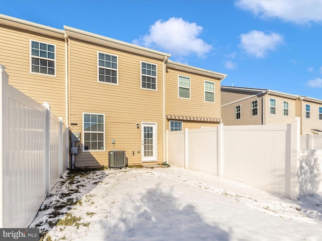 snow covered back of property with central AC unit