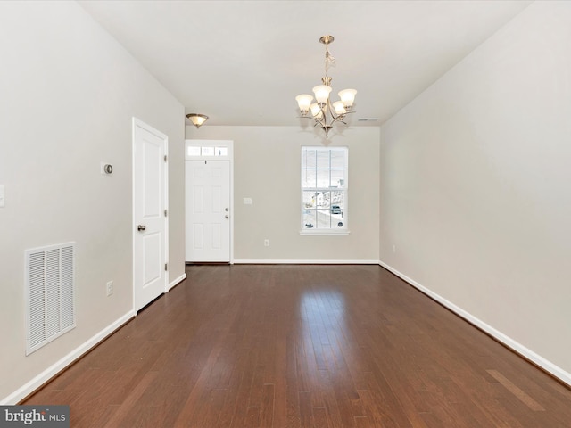 unfurnished room featuring dark hardwood / wood-style floors and a notable chandelier