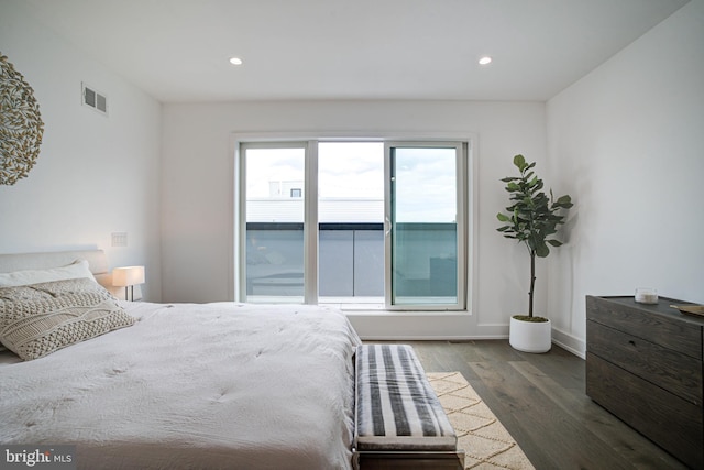 bedroom featuring multiple windows and dark hardwood / wood-style flooring