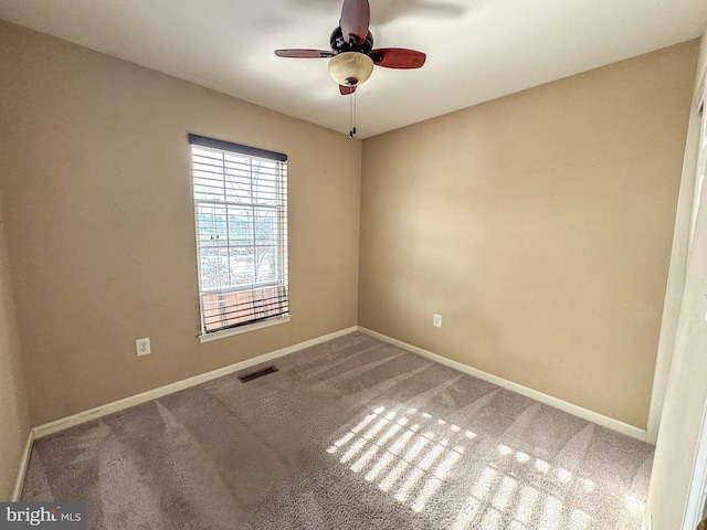 spare room featuring ceiling fan and carpet