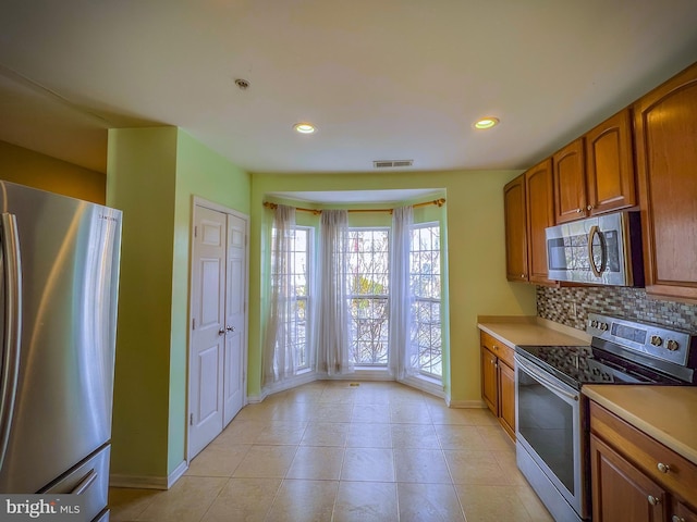 kitchen with stainless steel appliances and decorative backsplash