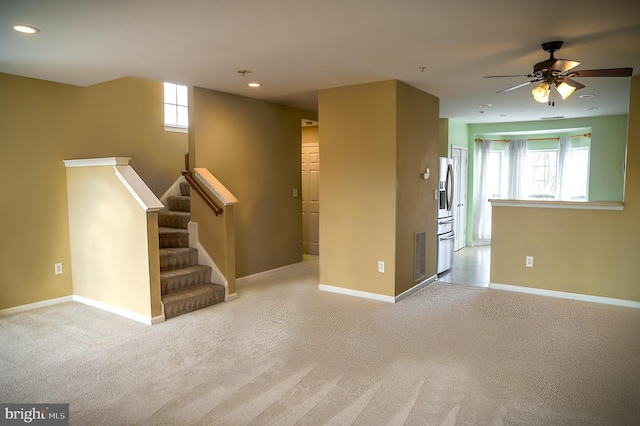 interior space with light carpet and ceiling fan