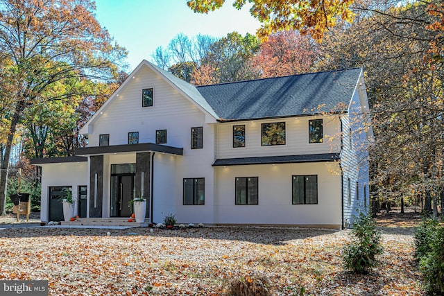 back of house with a shingled roof