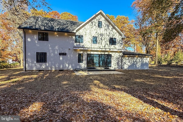 rear view of property featuring roof with shingles