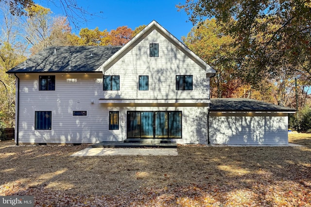 rear view of house with a shingled roof