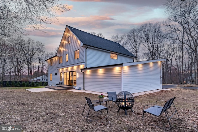 back of house with a patio, a shingled roof, and an outdoor fire pit
