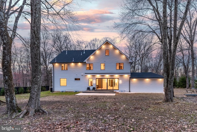 back of house featuring a shingled roof and a patio area