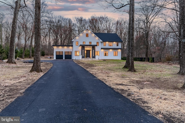 modern farmhouse style home with stucco siding, driveway, and a garage