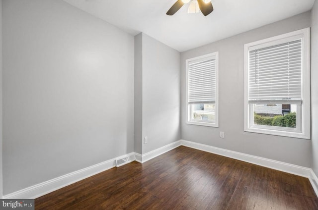 empty room with ceiling fan and dark hardwood / wood-style flooring