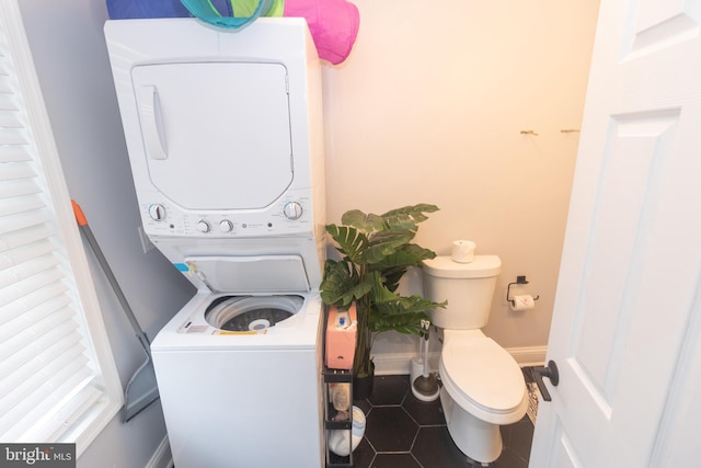 laundry area featuring stacked washer and dryer and tile patterned floors