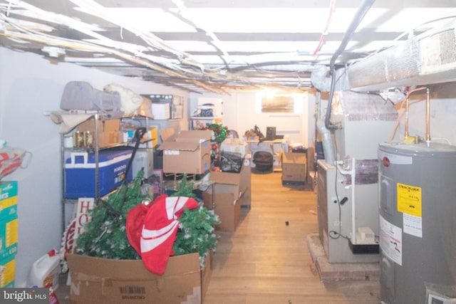 basement featuring light hardwood / wood-style flooring and electric water heater