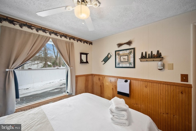 bedroom with ceiling fan and a textured ceiling