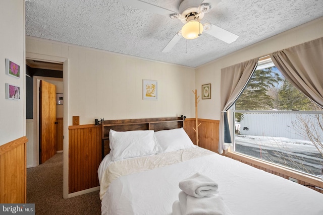 carpeted bedroom with ceiling fan and a textured ceiling