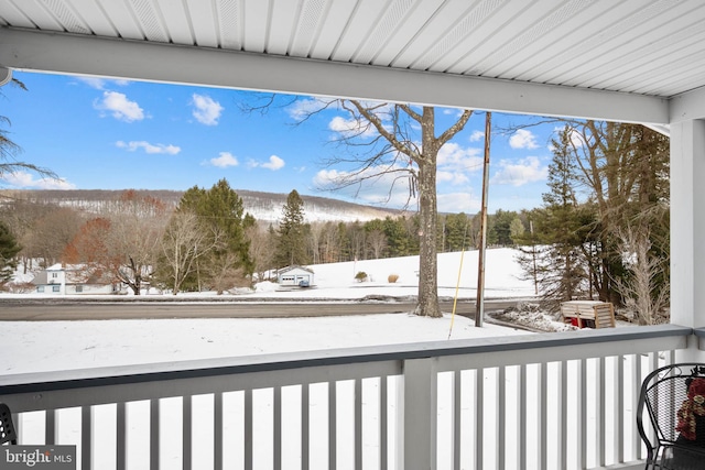 view of snow covered back of property