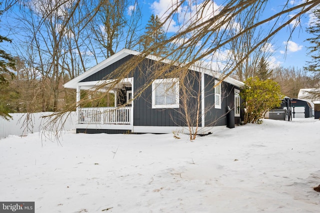 snow covered property with covered porch