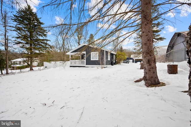 yard covered in snow featuring a porch