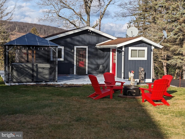 back of property with a mountain view, a yard, and a patio