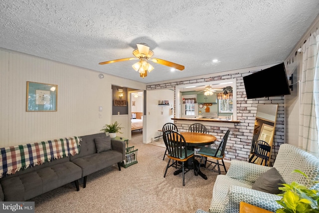 carpeted dining space featuring ceiling fan, a fireplace, and a textured ceiling