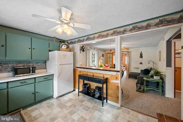 kitchen with ceiling fan, white fridge, and a textured ceiling