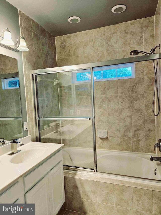 bathroom featuring vanity and shower / bath combination with glass door