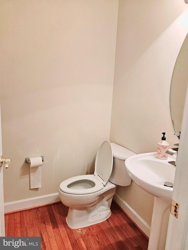 bathroom featuring wood-type flooring and toilet