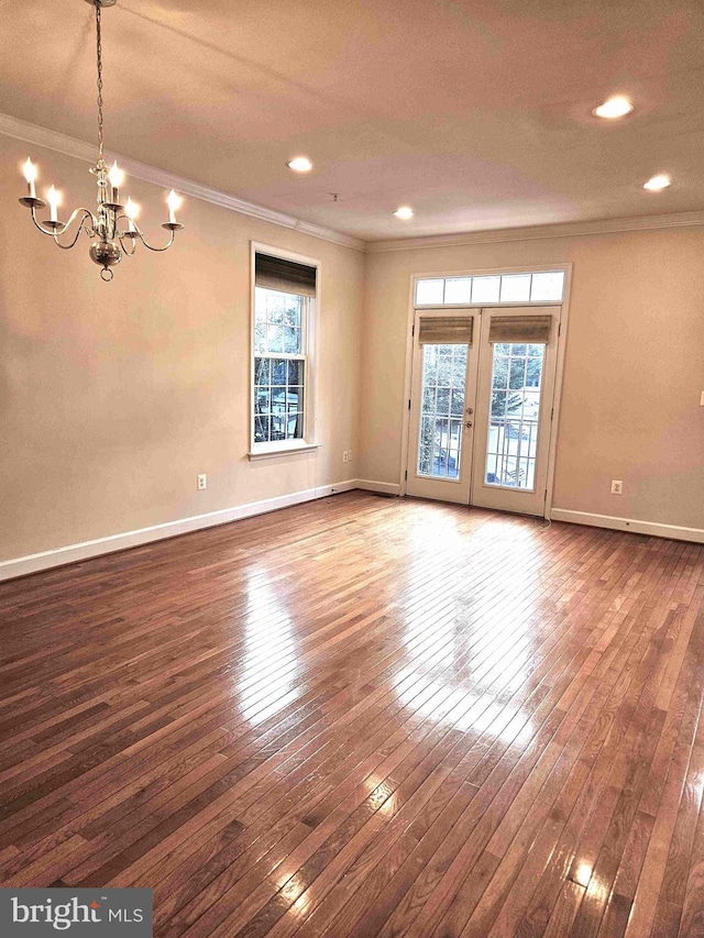 unfurnished room featuring crown molding, plenty of natural light, and wood-type flooring