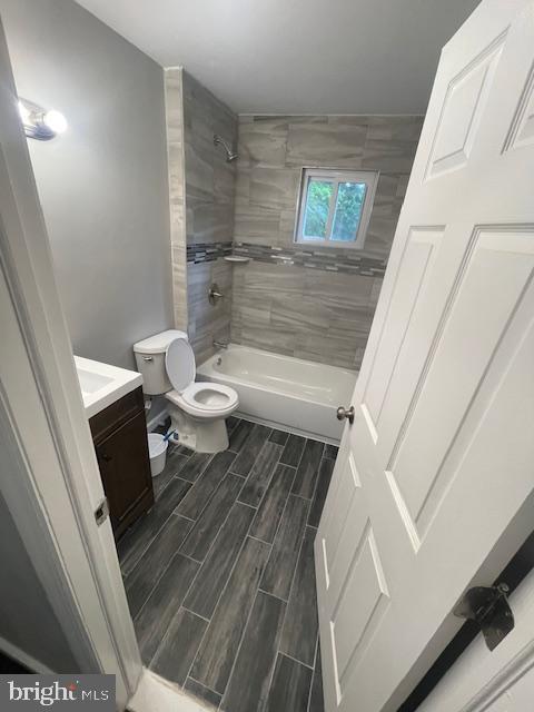 full bathroom featuring toilet, vanity, and tiled shower / bath combo