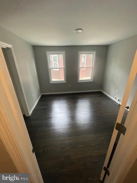 spare room with dark hardwood / wood-style floors