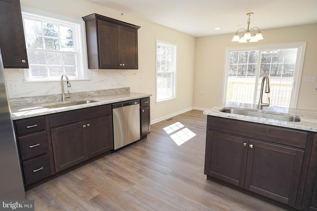 kitchen featuring light wood-type flooring, decorative backsplash, dishwasher, and sink