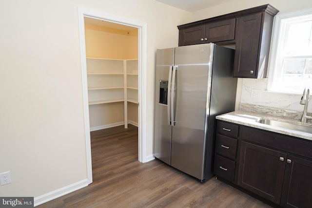 kitchen featuring sink, stainless steel fridge, dark hardwood / wood-style floors, and dark brown cabinets