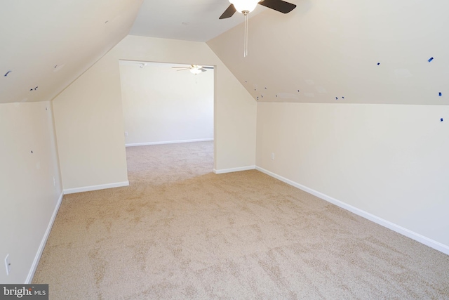 additional living space featuring ceiling fan, light colored carpet, and vaulted ceiling