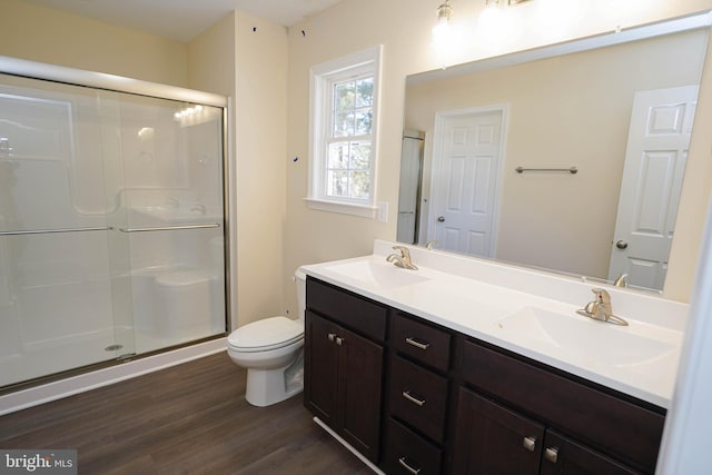 bathroom featuring toilet, hardwood / wood-style floors, an enclosed shower, and vanity