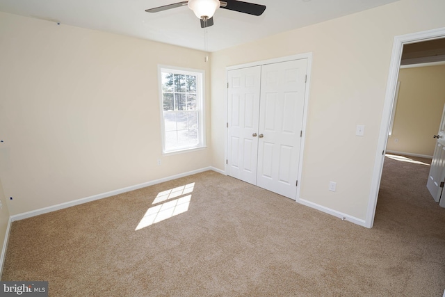 unfurnished bedroom with ceiling fan, a closet, and light carpet