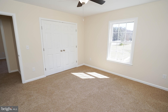 unfurnished bedroom featuring ceiling fan, a closet, and carpet flooring