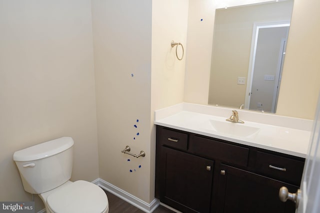 bathroom featuring toilet, hardwood / wood-style floors, and vanity