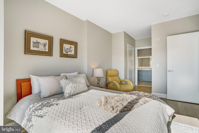 bedroom featuring hardwood / wood-style flooring and connected bathroom