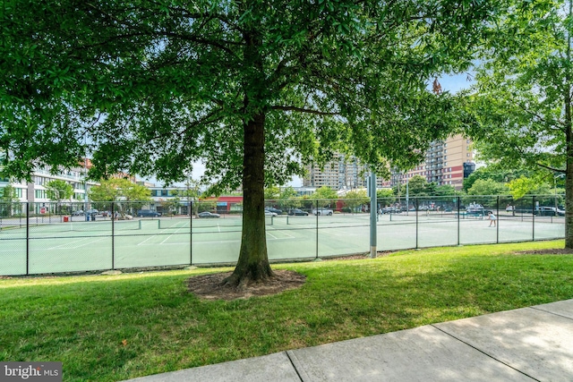 view of tennis court with a yard