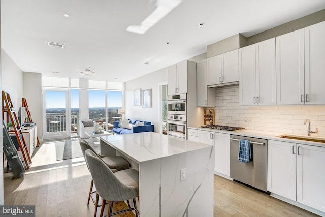 kitchen featuring light stone countertops, sink, white cabinetry, and stainless steel appliances