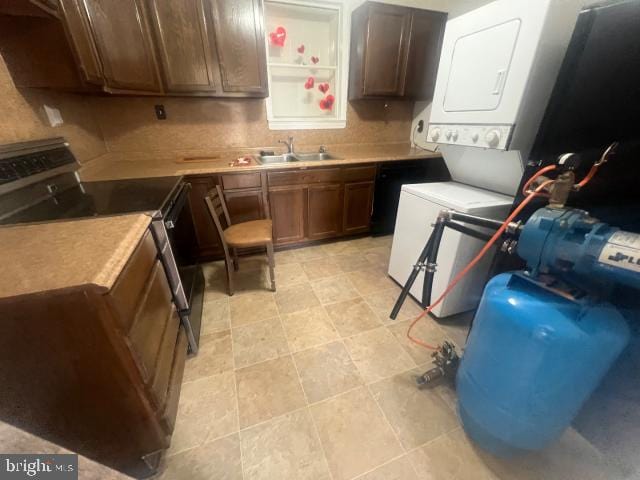 kitchen with stacked washer / drying machine, stainless steel electric range, and sink