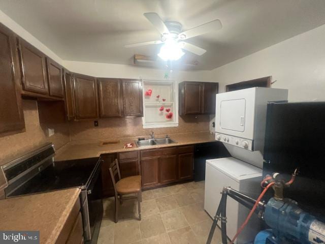 kitchen featuring electric stove, ceiling fan, sink, stacked washer and dryer, and dark brown cabinets